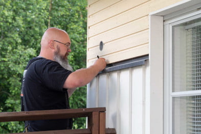 Ilmalämpöpumpun asennus Tehotikka asentamassa ilmalämpöpumppua