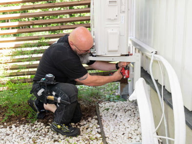 Ilmalämpöpumpun huolto Tehotikka huoltamassa ilmalämpöpumppua